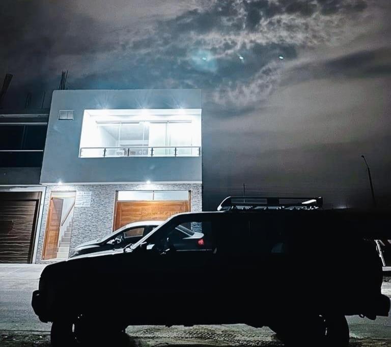 une jeep garée devant un bâtiment la nuit dans l'établissement Alquiler departamento Asia - la alborada, à Asia