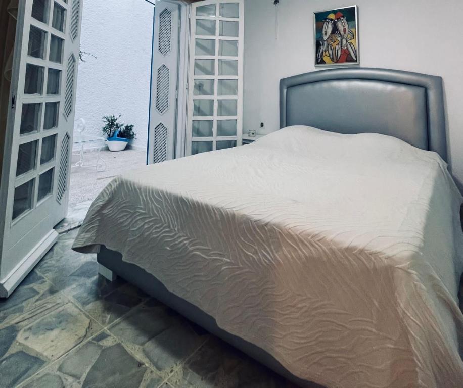 een groot bed in een kamer met een deur bij La Maison Bleue in Dar Salah Bey