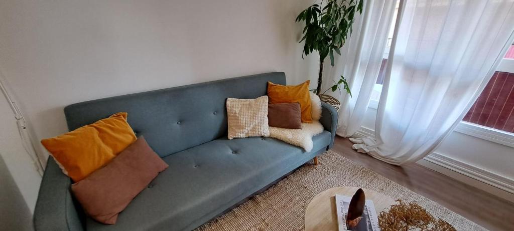 a blue couch with pillows on it in a living room at Apartamento con suite, zona de trabajo y yoga wifi y garaje in Castro-Urdiales