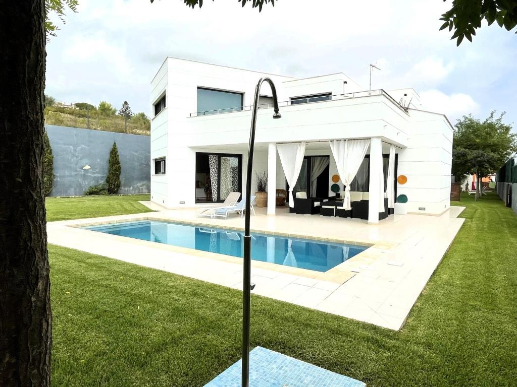 a white house with a pool in front of it at Chalet Irlanda Luxury in Peñíscola