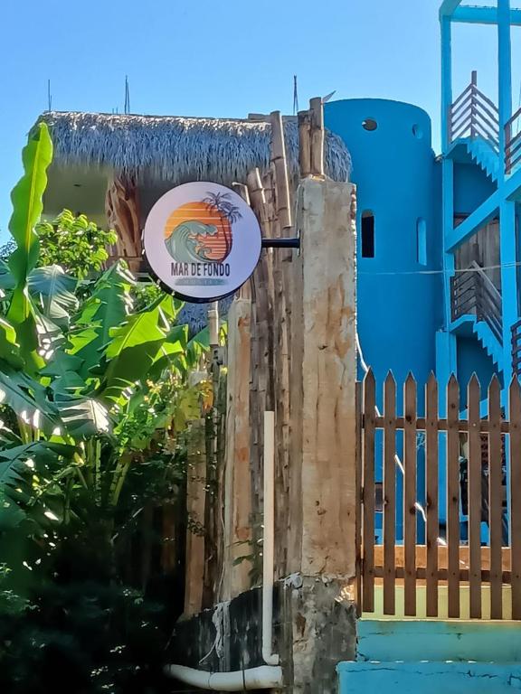 een bord aan de zijkant van een blauw gebouw bij Mar de Fondo in Puerto Escondido
