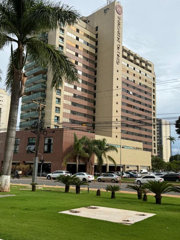 a large building with palm trees in front of it at Lindo Flat Particular decorado in Brasilia