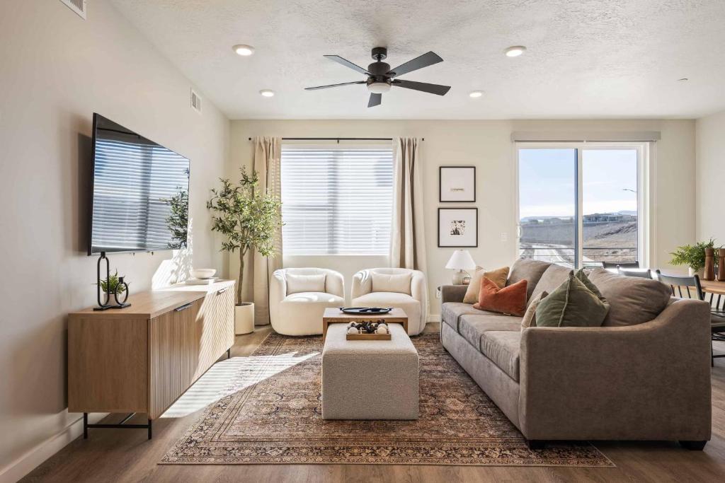 een woonkamer met een bank en een plafondventilator bij Drop it like it's Hot condo in St. George