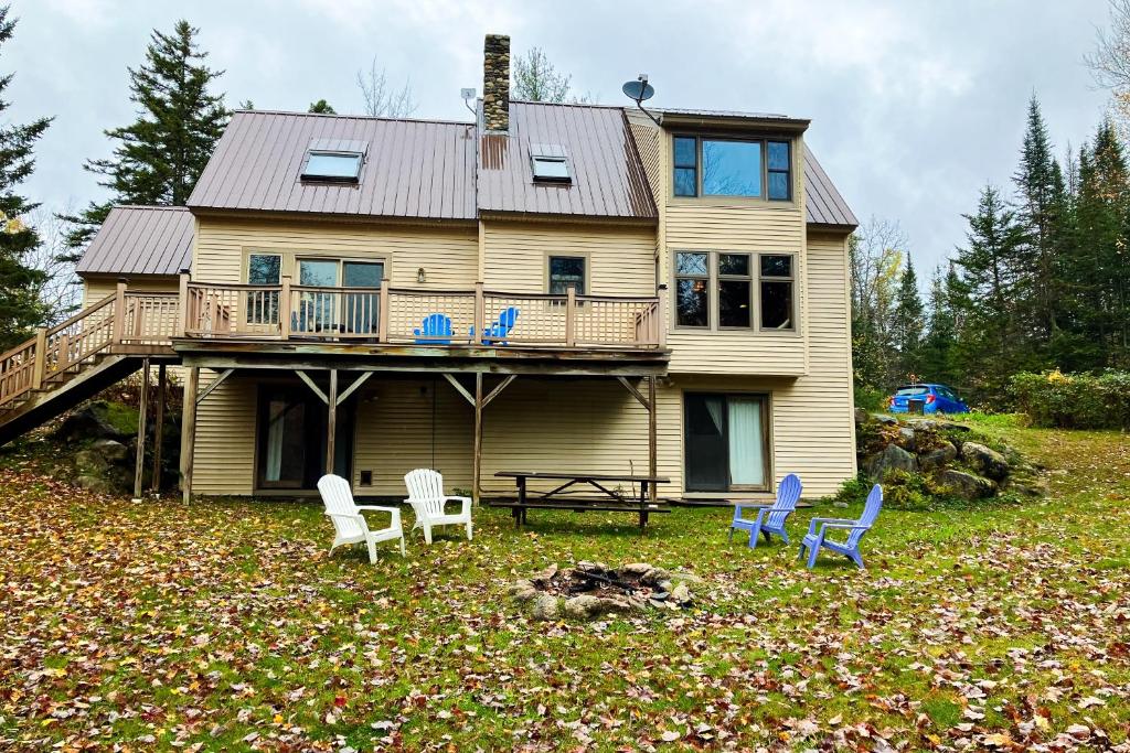 una casa con terraza y sillas en el patio en Peaceful Mountain Delight en East Burke