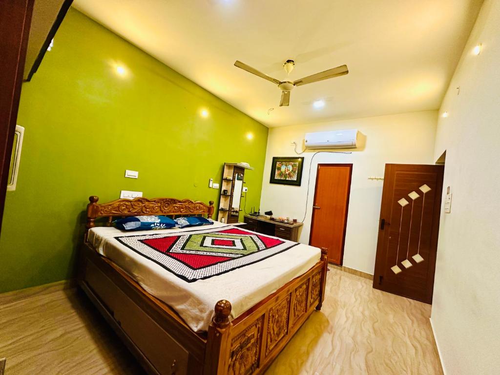 a bedroom with a bed with a green wall at SS Home Stay Accomodation in Tiruvannāmalai