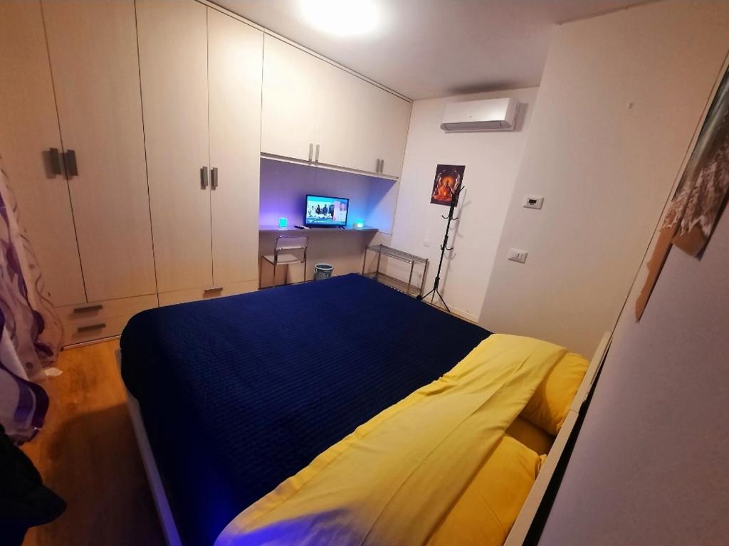 a bedroom with a bed with a blue and yellow blanket at New Bedrooms Mamma Gigetta in Noventa di Piave