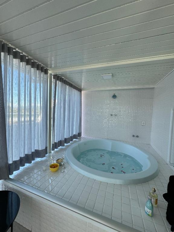 uma casa de banho com uma grande banheira num quarto em Duplex Ametista em Gravatal