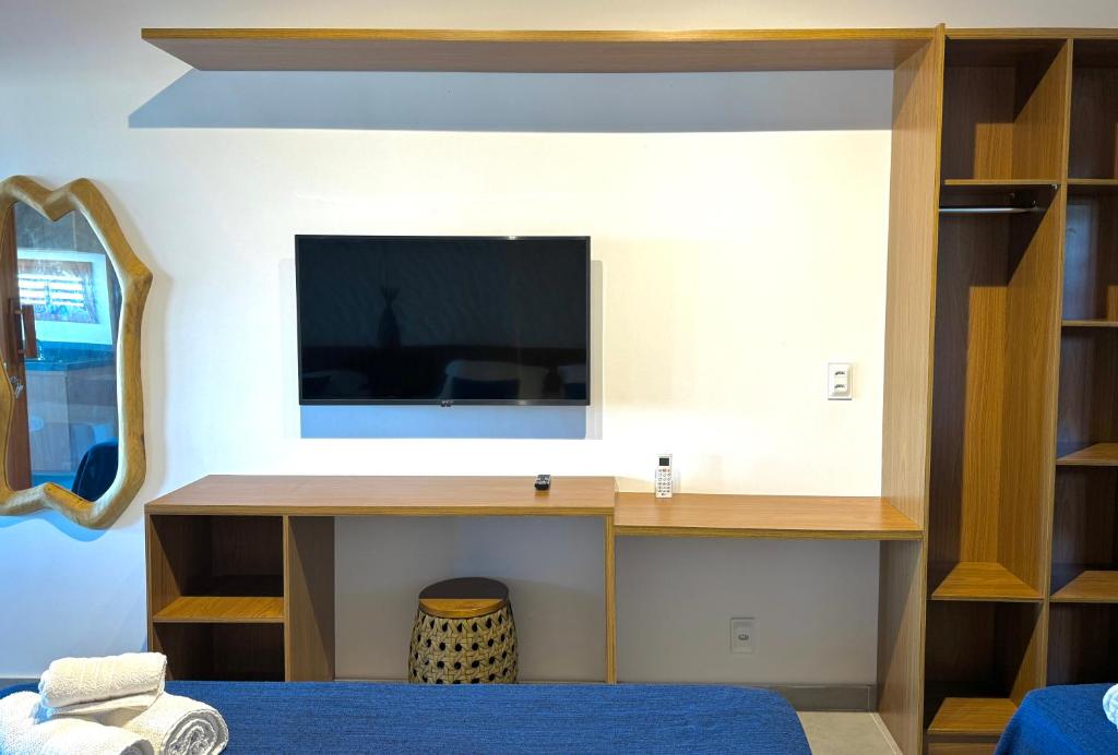 a bedroom with a tv on a wall at Pousada Lá em Casa in Barra Grande