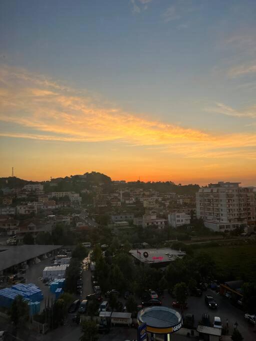 a view of a city with the sunset in the background at Asli's Comfy Studio APT in Tirana
