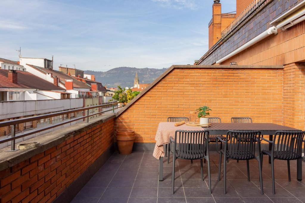 - une terrasse avec une table et des chaises dans un bâtiment dans l'établissement El Mirador de la Catedral de Oviedo, à Oviedo