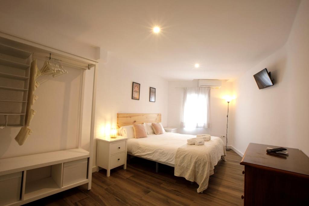 a white bedroom with a bed and a window at Apartamento Deluxe El balcón de la Trinidad Córdoba in Córdoba