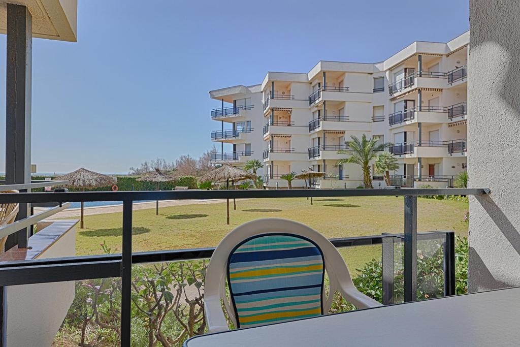 einen Balkon mit einem Stuhl und einem Gebäude in der Unterkunft Apartamento en Creixell Primera linea de playa. in Creixell