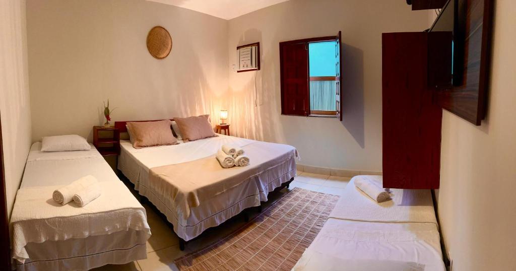 a room with two beds and a window at La Bahianita in Itacaré