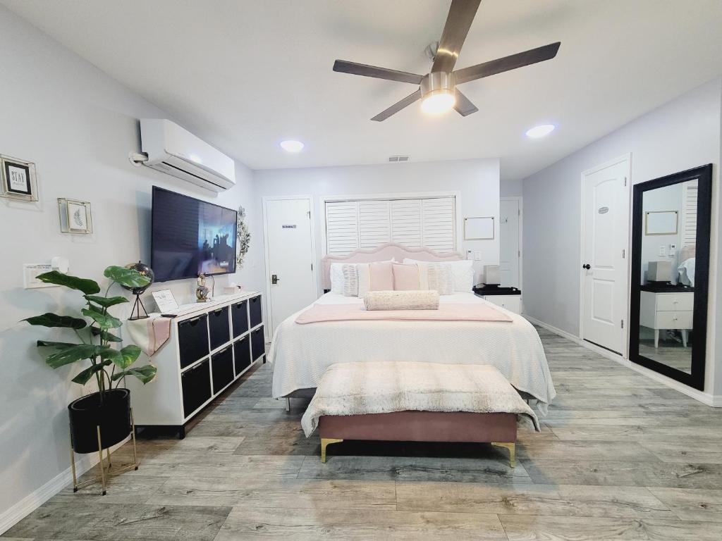 a white bedroom with a bed and a ceiling fan at Modern Dream Rooms Suits - Private, parking, Wi-Fi, Netflix in Spring Hill