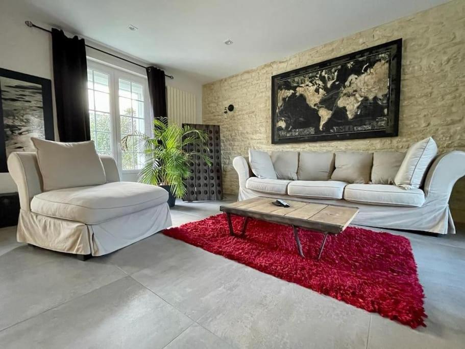 - un salon avec un canapé blanc et un tapis rouge dans l'établissement Charmante maison de 110m2 située à Luc à 800 m de la mer, à Luc-sur-Mer