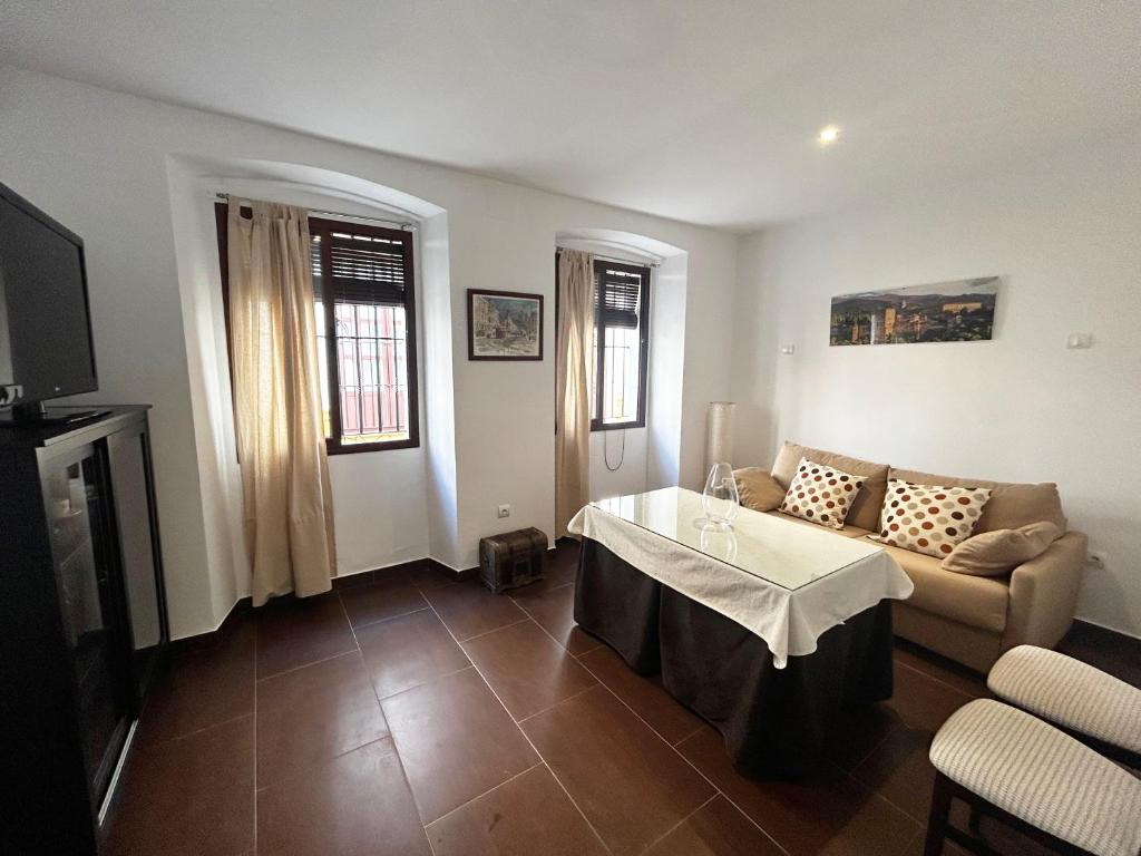 ein Wohnzimmer mit einem Sofa und einem Tisch in der Unterkunft Bonito apartamento en Utrera WIFI gratis in Utrera