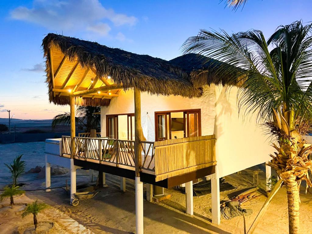 a house on the beach with a palm tree at Jurema Branca Villa in Beberibe
