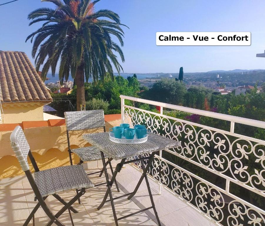 une table et des chaises sur un balcon avec un palmier dans l'établissement Superb renovated apartment with sea view for 5, à Cagnes-sur-Mer