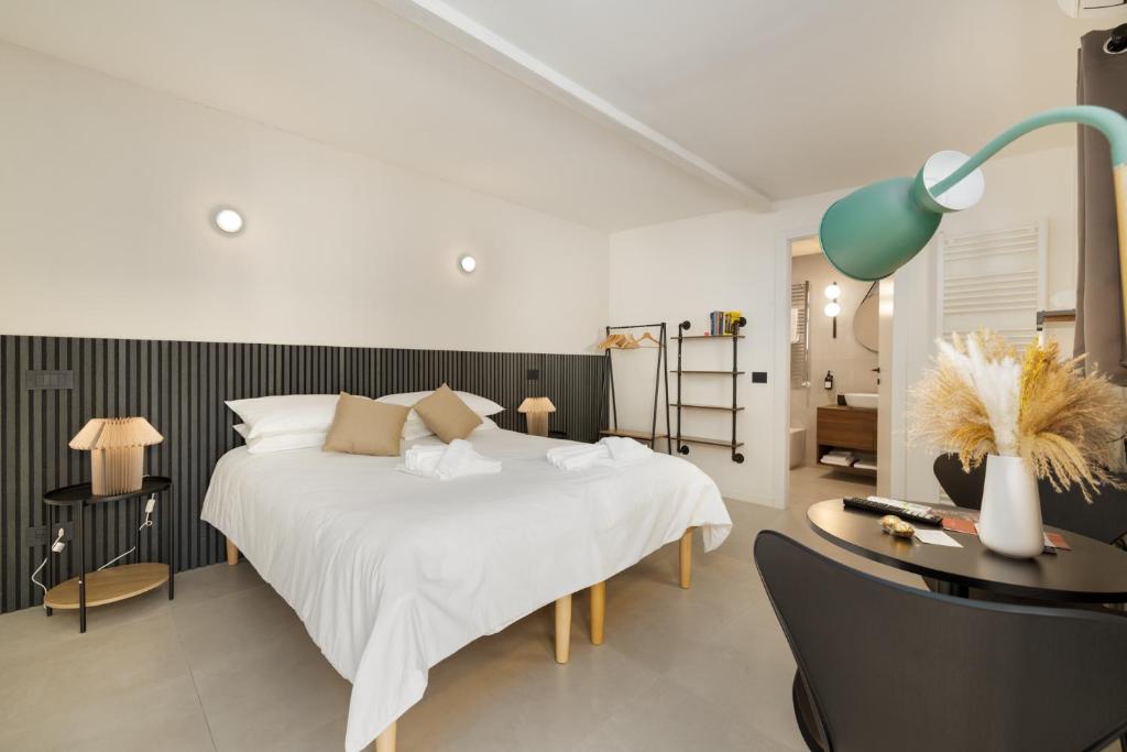 a bedroom with a white bed and a desk with a lamp at La casetta di Grace in Sesto Fiorentino