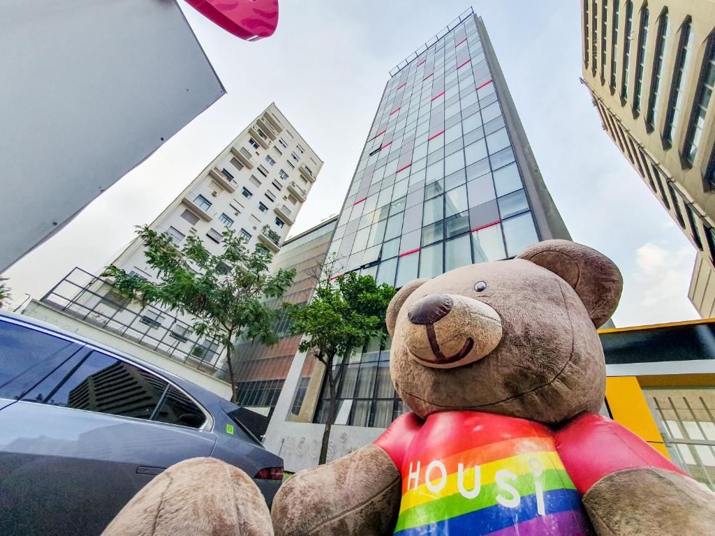 a teddy bear sitting in front of a building at Housi Paulista in São Paulo