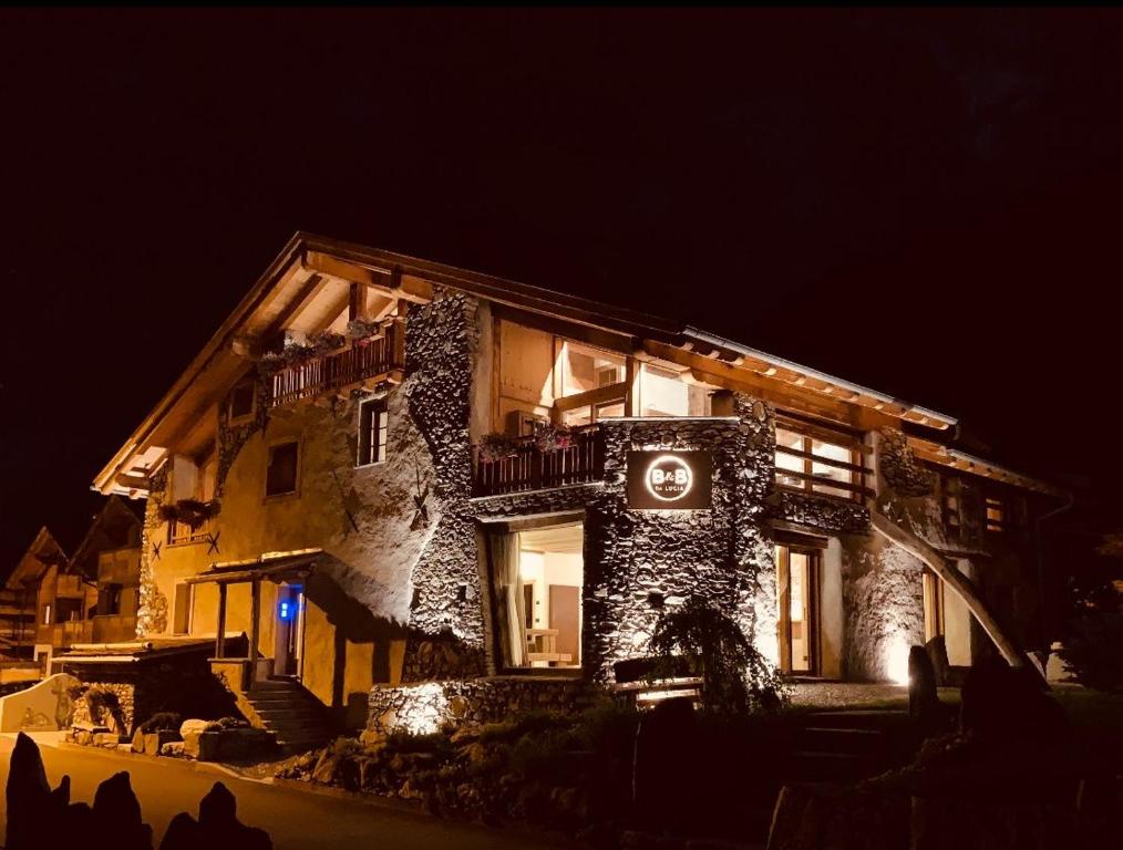 a large building with a sign on it at night at B&B da Lucia 2 Bormio in Valdisotto