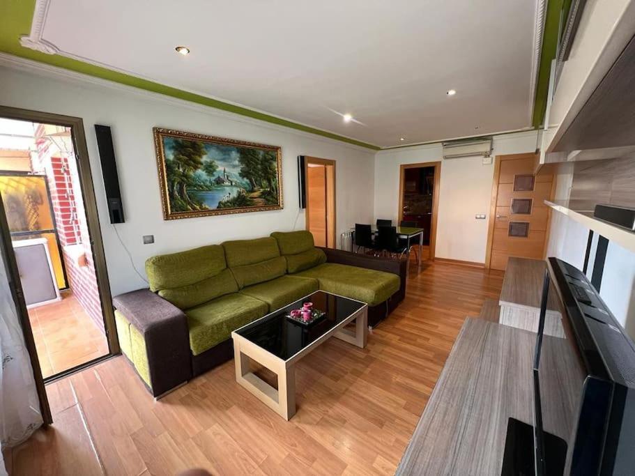 uma sala de estar com um sofá verde e uma televisão em Cozy apartment for 6 people - Port Aventura em Vilaseca de Solcina