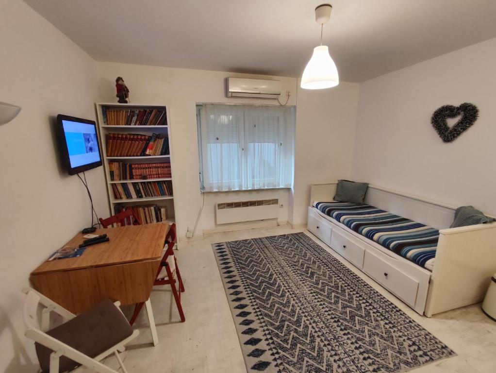 uma sala de estar com um sofá, uma mesa e uma secretária em Balkan-Inn Apartments em Belgrado