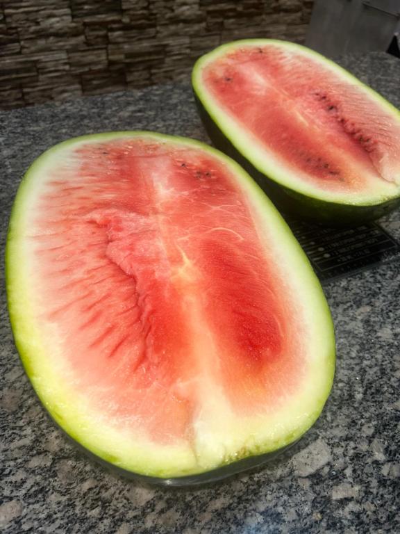 two halves of a watermelon sitting on a table at Lobi Home Stays in Kubuta