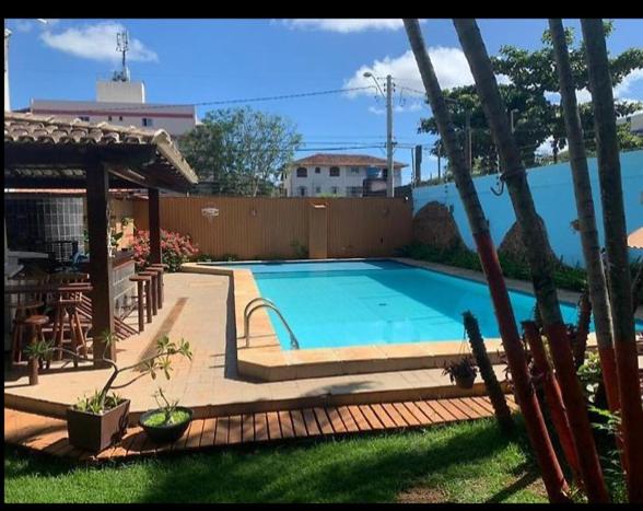 une grande piscine dans une cour avec une clôture dans l'établissement Espaço Hale Kai, à Guarapari