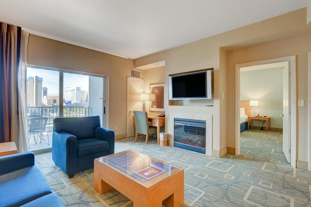 a living room with a blue couch and a fireplace at Princess II Suite Platinum * Balcony Strip Views in Las Vegas