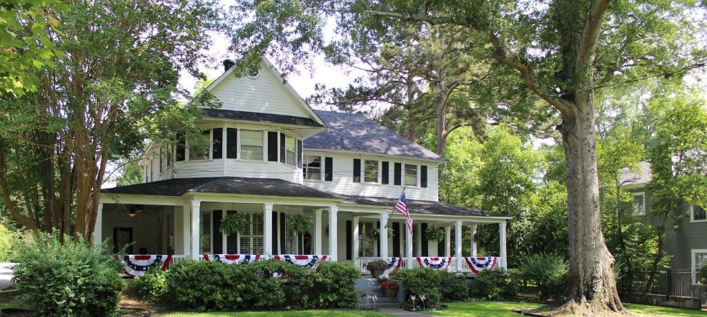 Una casa blanca con una bandera americana. en Huffman House Bed & Breakfast, en Minden