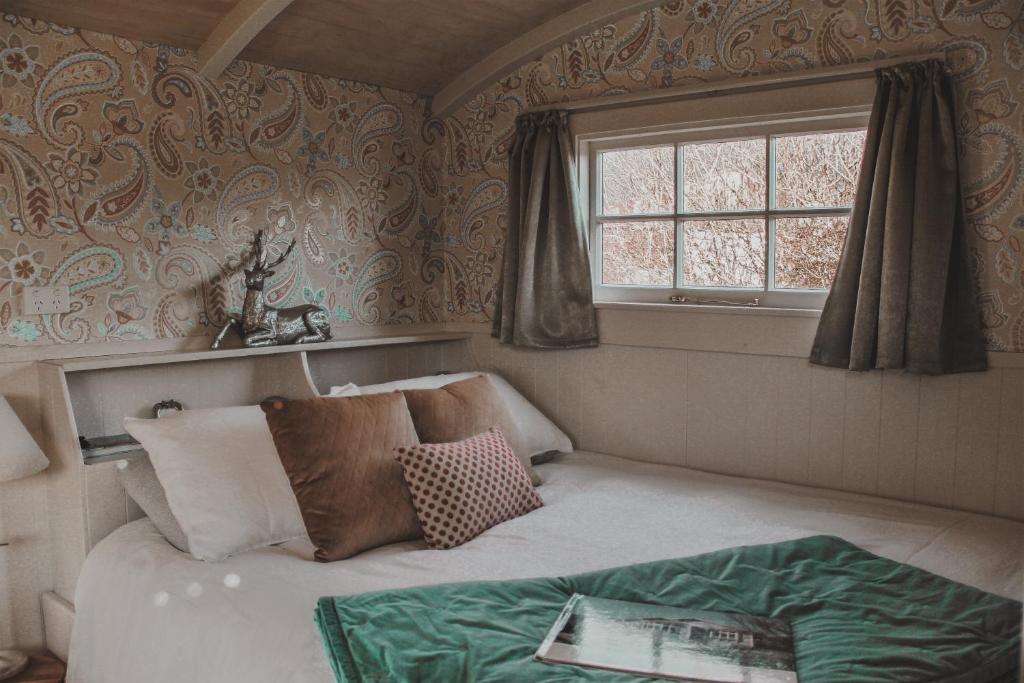 Dormitorio pequeño con cama y ventana en Rocky Creek Shepherds Hut, en Fox Glacier