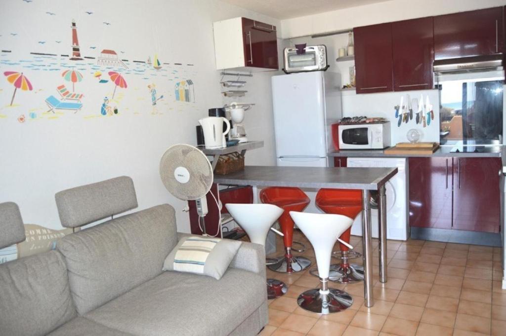 un salon avec un canapé et une table dans une cuisine dans l'établissement Résidence Grande Bleue - 2 Pièces 4 couchages PORT LEUCATE MAE-6694, à Port-Leucate