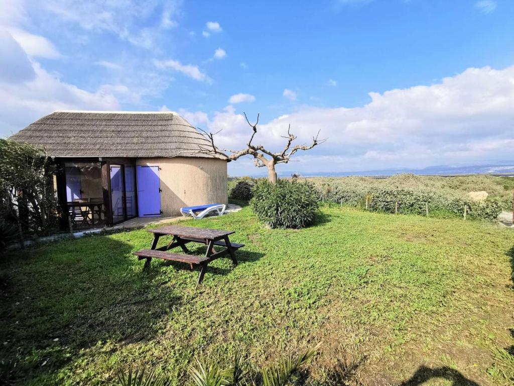 une table de pique-nique dans l'herbe à côté d'un bâtiment dans l'établissement Résidence Ile Des Pecheurs - VILLA 3 PIECES 6 couchages LE BARCARES MAE-1314, à Port-Leucate