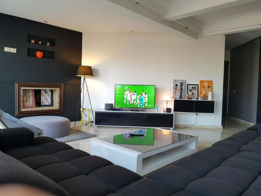 a living room with a couch and a tv at Modern Apartment Horizon with Great Front View, Casablanca in Casablanca