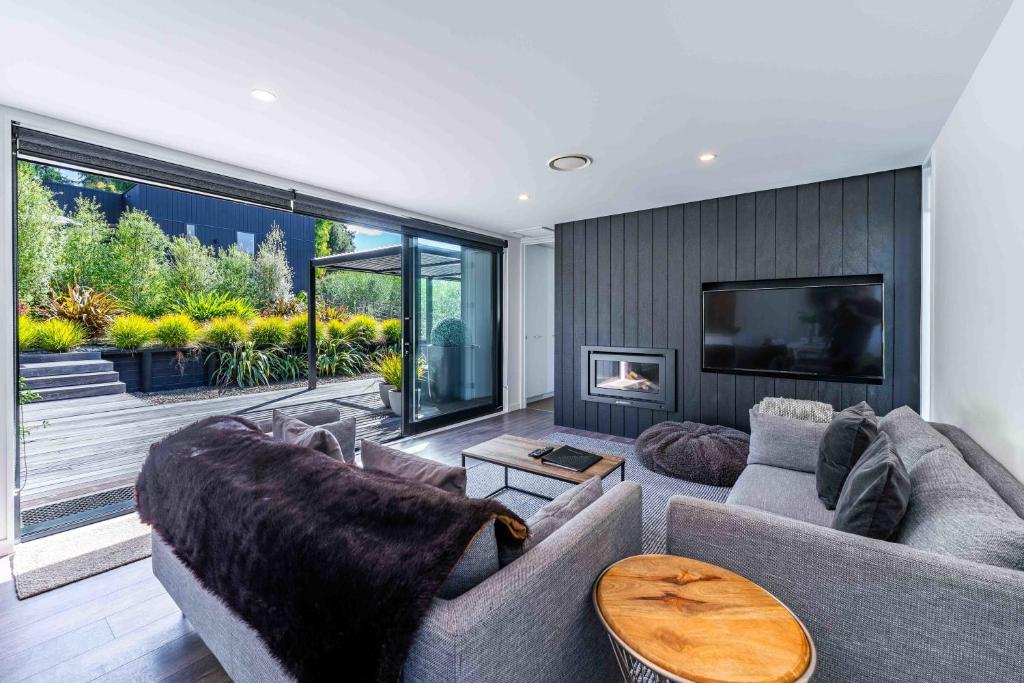 a living room with a couch and a fireplace at Noir South Retreat in Wanaka