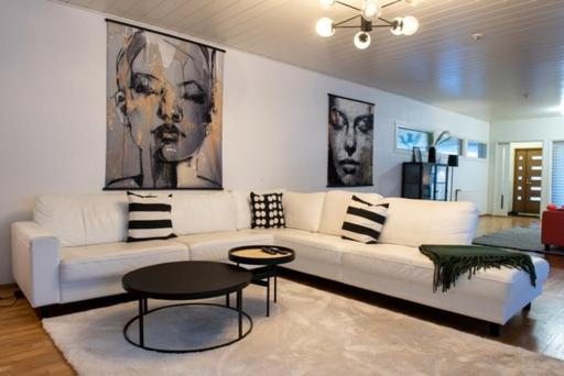 Una sala de estar con un sofá blanco y una mesa. en Villa Koivu 100m2 3mh, rauhallinen ja tyylikäs kaupunkikoti, en Seinäjoki