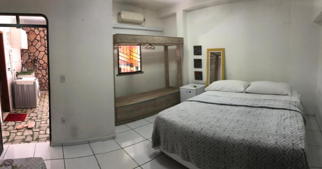 a bedroom with a bed and a bath room at Pousada das Flores. in Boa Vista