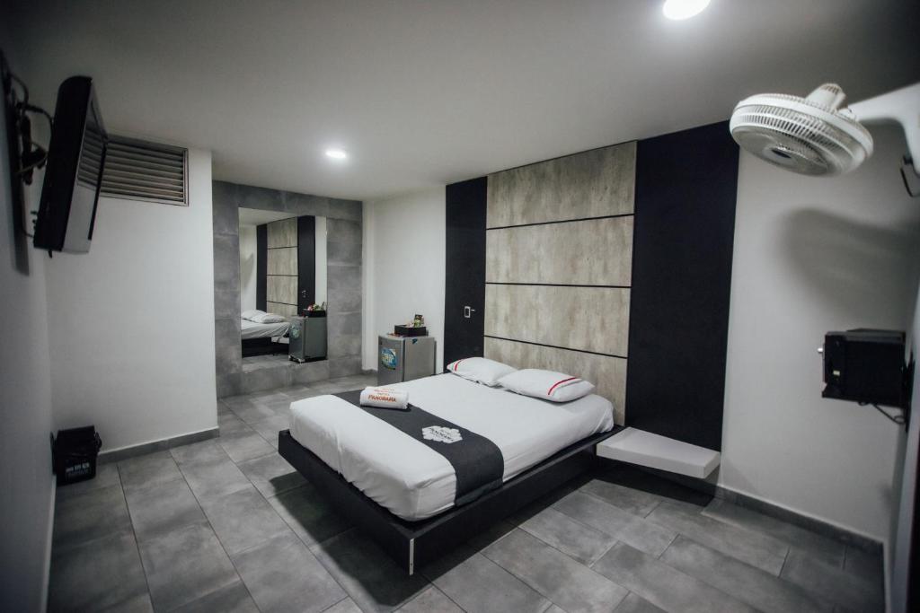 een slaapkamer met een groot bed en een badkamer bij Hotel Panorama Medellín in Medellín