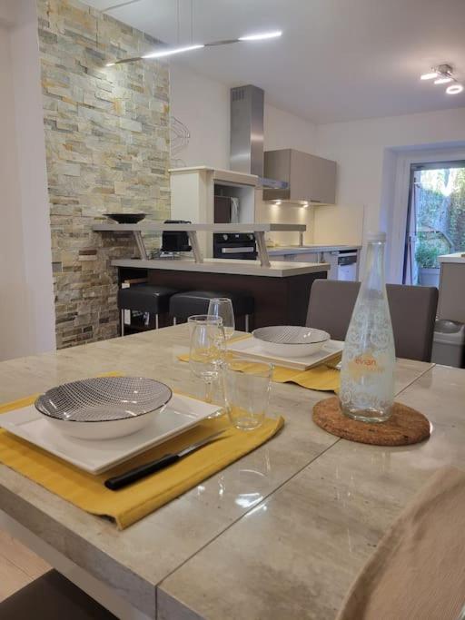 - une cuisine avec une table avec des verres et un vase dans l'établissement Dumur - centre ville Evian, à Évian-les-Bains