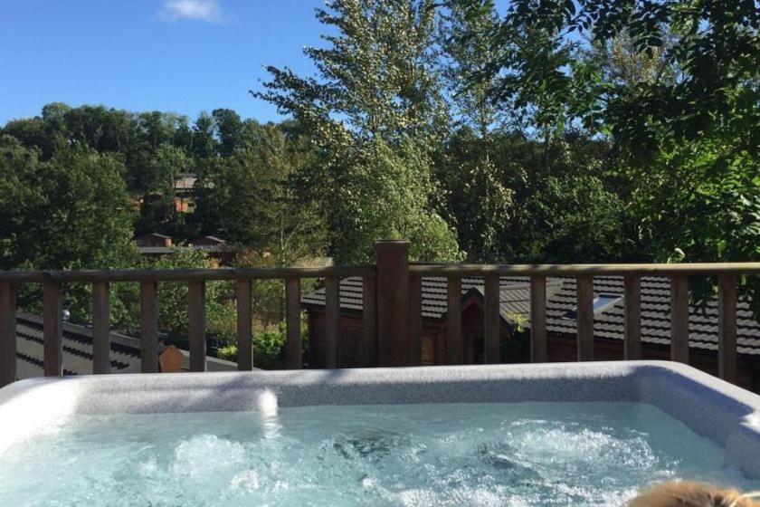 a hot tub on top of a wooden deck at Luke's Lodge in Newton Abbot