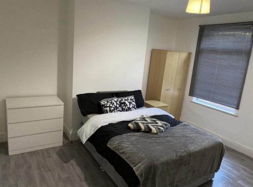 a bedroom with a bed and a dresser at Short term let Room In DE1 in Derby