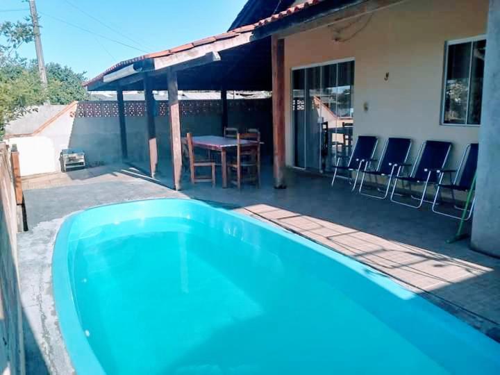 a blue swimming pool in front of a house at Casa B com Piscina Enseada Ubatuba Max06 Hosp in São Francisco do Sul