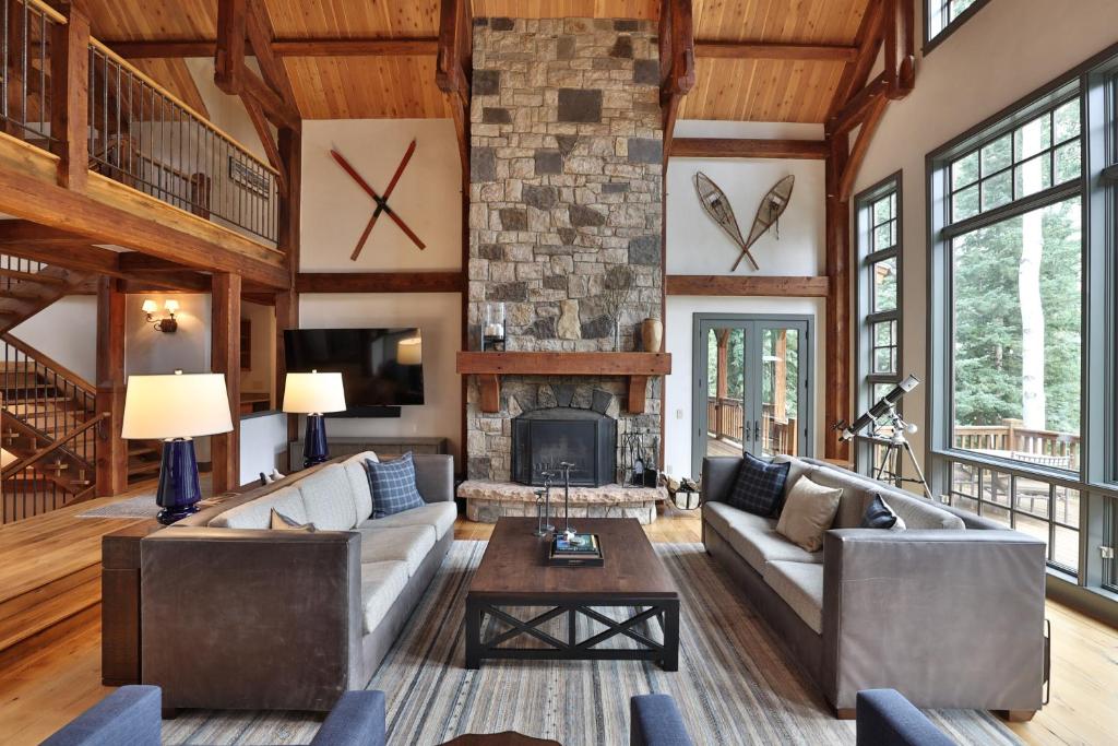 a living room with a fireplace and a stone wall at Mountain Village Marvel with Hot Tub and Home Gym! in Telluride