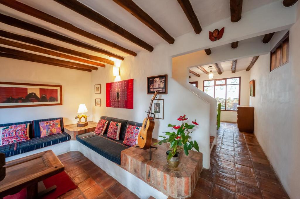 sala de estar con sofá y guitarra en Casa de Las Aguas, en Villa de Leyva