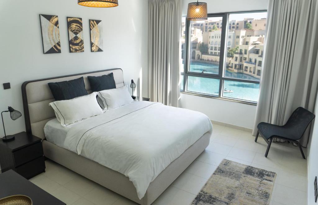 a bedroom with a large bed and a large window at Downtown Oasis, Burj Khalifa Views, Luxury Amenities in Dubai