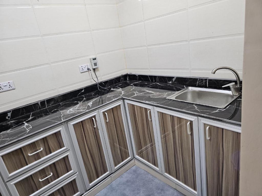 a kitchen with a sink and a counter top at Double A apartment in Ngambo