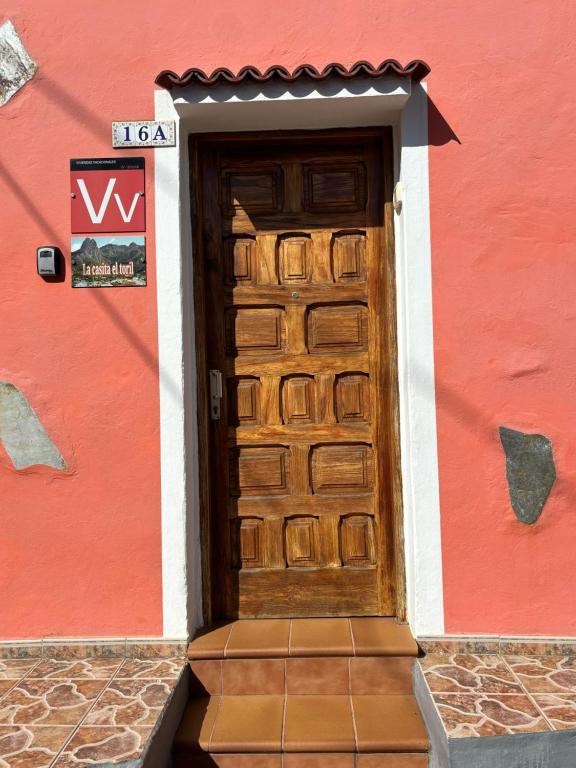 a wooden door on a red building with a sign at Chalet Rutas de Valsequillo in Valsequillo