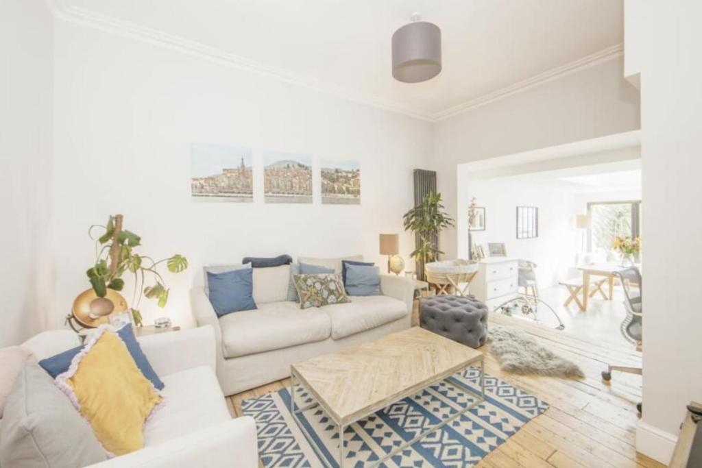 a living room with a white couch and a table at Striking & Modern 2BD Flat wGarden - East Dulwich in London