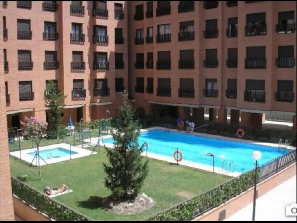 a large swimming pool in front of a building at Apartamento turístico plenilunio suite, airport, wanda, ifema in Madrid